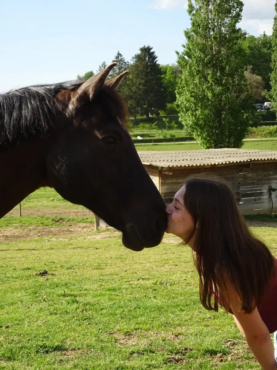 Emily as a teenager kissing her horse